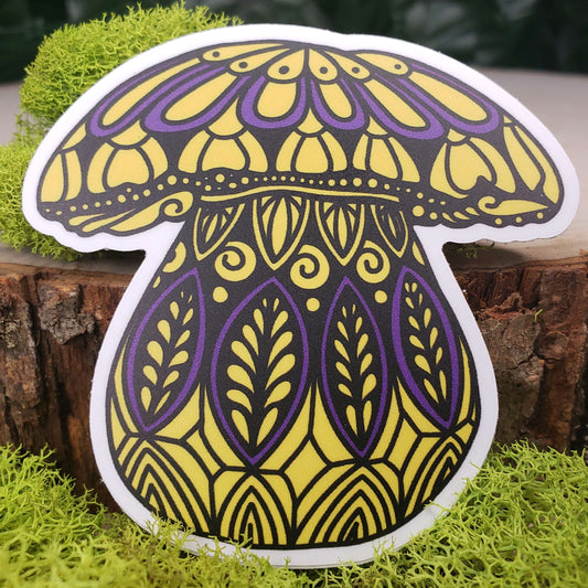 Sticker of a yellow and purple king bolette mushroom with stark black line art reminiscent of henna tattoo art. the sticker is sitting on moss and wood with ivy leaves in the background