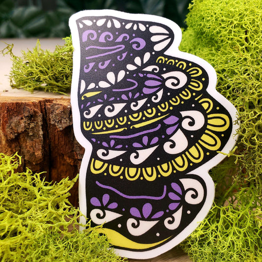 Sticker of purple, yellow, and cream pheasant back mushrooms with stark black line art reminiscent of henna tattoo art. the sticker is sitting on moss and wood with ivy leaves in the background